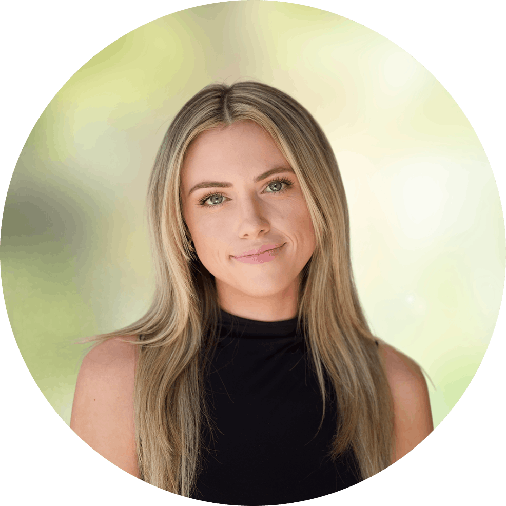 nina headshot 1 - Bakersfield Recovery Center Portrait of a smiling woman with long blonde hair wearing a black sleeveless top, outdoors.